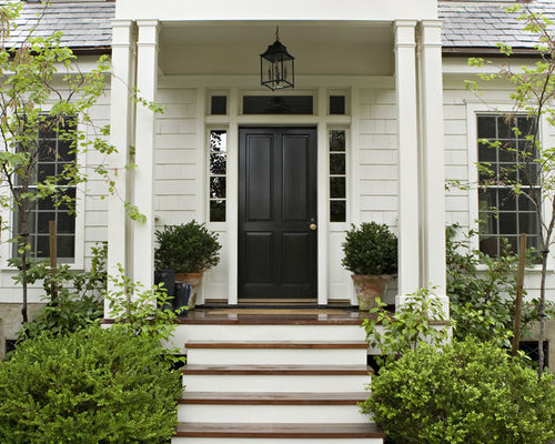 white home with soft and hard landscaping surrounding front entry